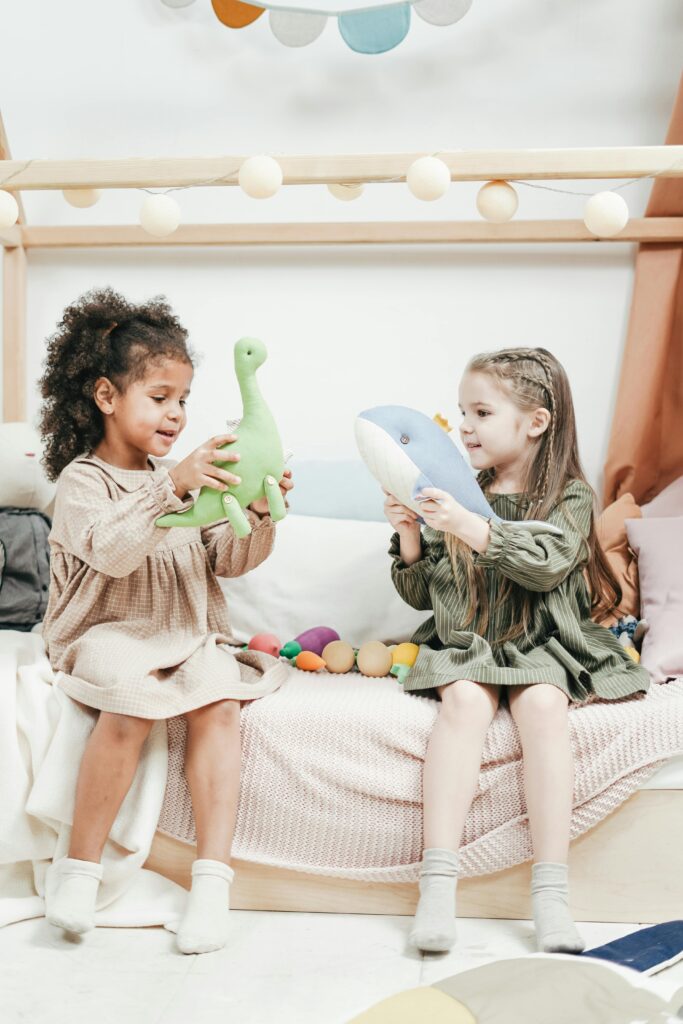 Two girls playing with dinosaur toys